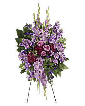 Lavender & Purple Blooms With Fresh Green Ti Leaves In Standing Sympathy Arrangement. Same Day Flower Delivery. Teleflora Lavender Reflections Spray.